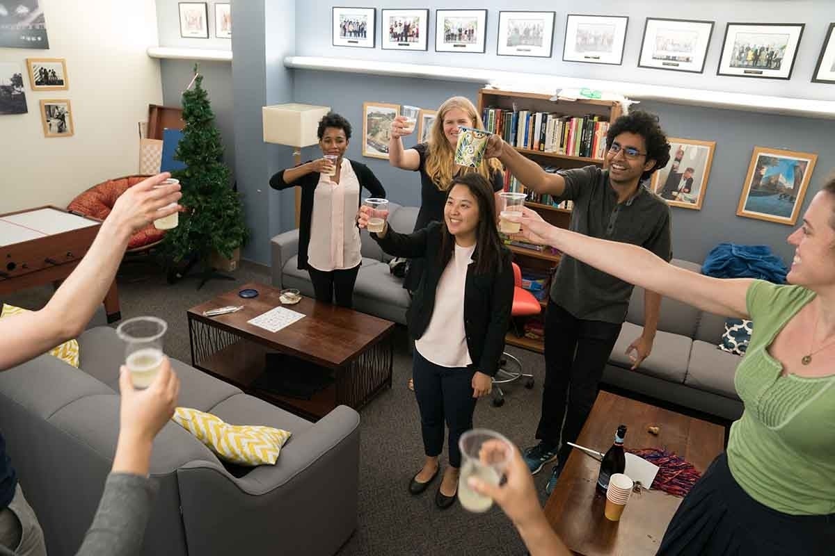 Group of people making a champagne toast in the grad lounge